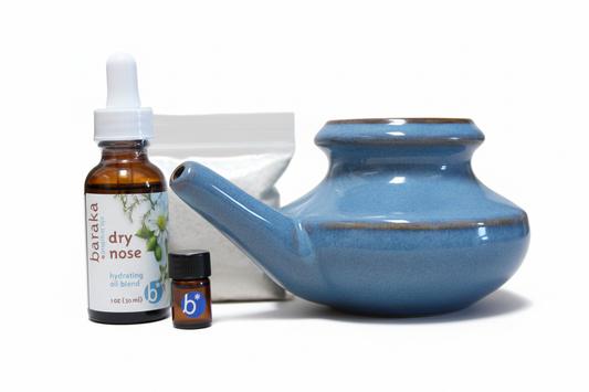 Blue ceramic neti pot with dry nose oil, bag & of 2oz Sea Salt, and 1 ml Sinus oil bottle on a white background