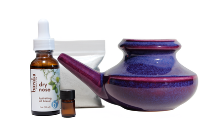 Purple ceramic neti pot with dry nose oil, bag & of 2oz Sea Salt, and 1 ml Sinus oil bottle on a white background